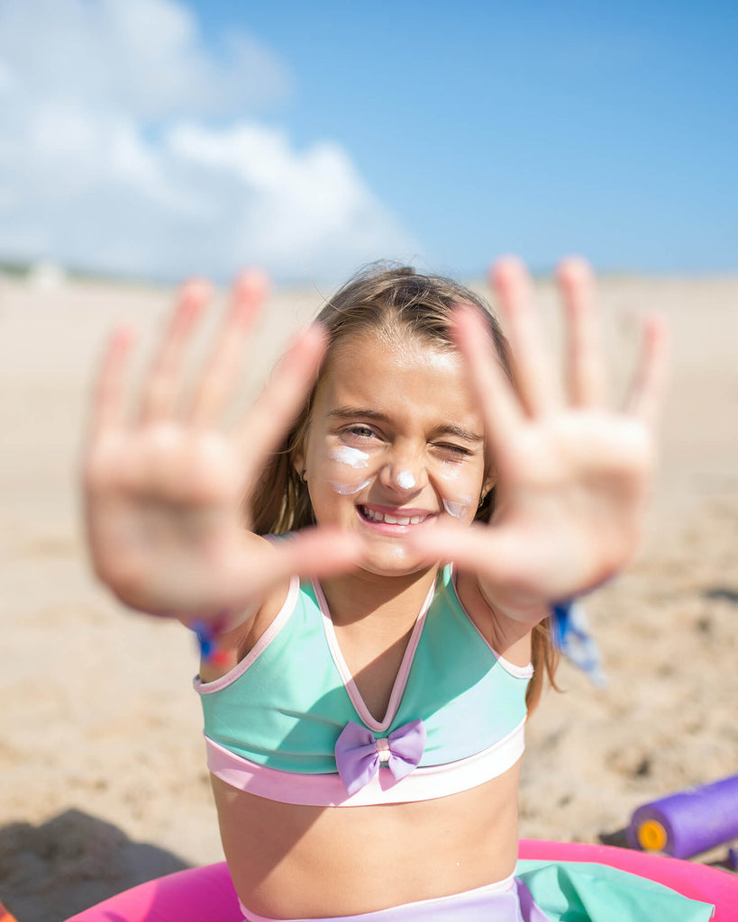 young girl with sunblock on hands